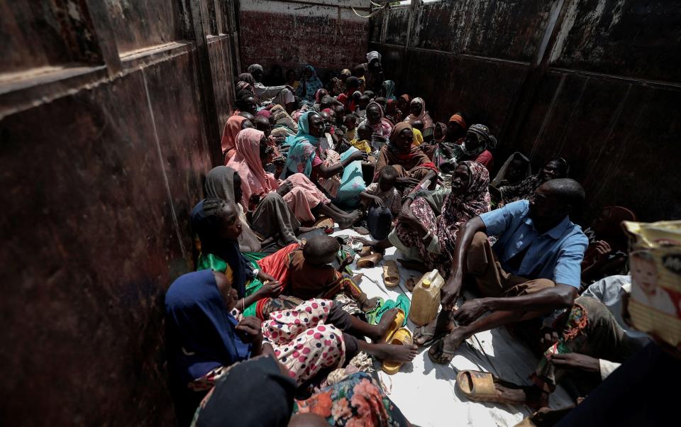 Sudanese people who fled the conflict in Geneina in Sudan's Darfur region, sit on a truck that will relocate them from a school where they were temporarily accommodated to a refugee camp in Adre, Chad