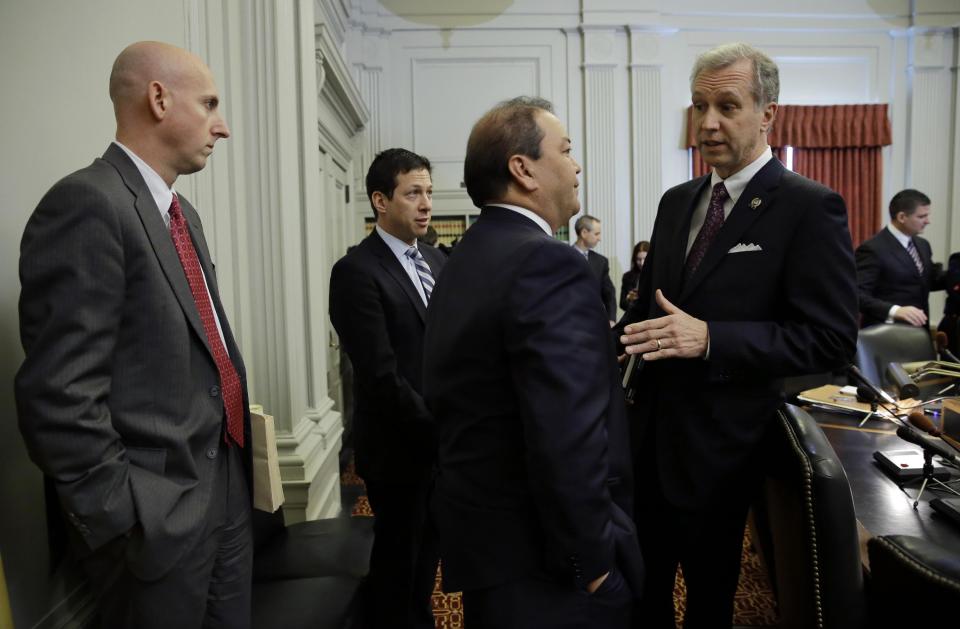 Attorney Reid Schar, left, stands with fellow attorney Anthony Barkow, second from left, as New Jersey Assemblyman John S. Wisniewski, right, D-Sayreville, N.J., co-chair of a joint bipartisan committee of members of the New Jersey Senate and Assembly, talks with Sen. Kevin J. O'Toole, R-Wayne, N.J., before a meeting at the Statehouse in Trenton, N.J., Monday, Feb. 10, 2014. More subpoenas are expected to be issued by a New Jersey legislative committee investigating a plot to create gridlock by blocking lanes near the George Washington Bridge. (AP Photo/Mel Evans)