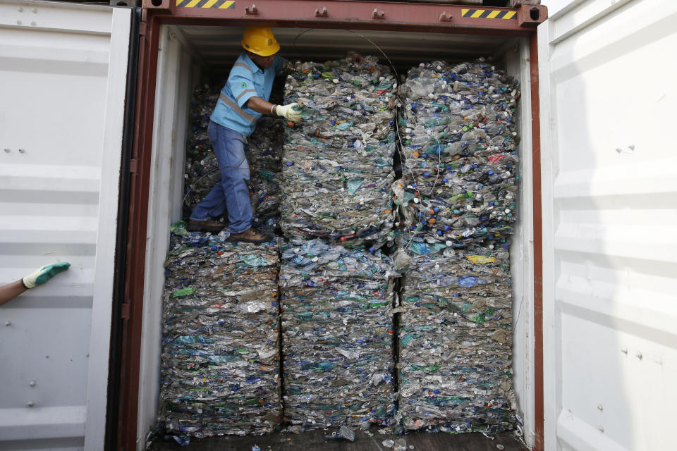 A worker stands inside a container full of plastic waste at Tanjung Priok port in Jakarta, Indonesia Wednesday, Sept. 18, 2019. Indonesia is sending hundreds of containers of waste back to Western nations after finding they were contaminated with used plastic and hazardous materials. (AP Photo/Achmad Ibrahim)