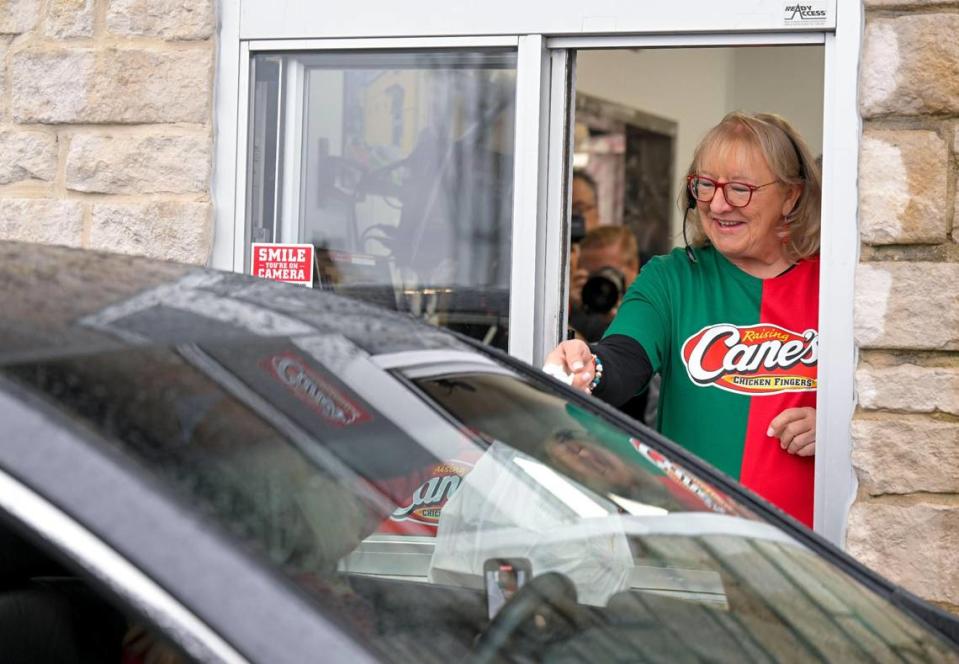 Donna Kelce, the mother of Chiefs tight end Travis Kelce and Eagles center Jason Kelce, serves up chicken wings while “working” the drive-thru at Raising Cane’s Monday in Overland Park.