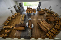 Coffins arriving from the Bergamo area, where the coronavirus infections caused many victims, are being unloaded from a military truck that transported them in the cemetery of Cinisello Balsamo, near Milan in Northern Italy, March 27, 2020. (Claudio Furlan/LaPresse via AP)