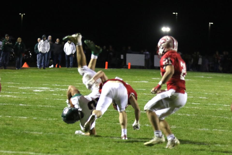 Oak Harbor's Hayden Buhro is upended after a catch.