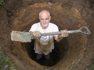 Man in a hole, showing a shovel