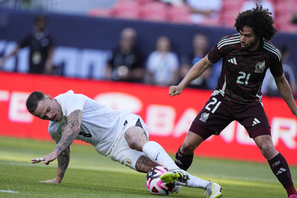 El uruguayo Nahitan Nández (izquierda) roba el balón al mexicano César Huerta durante el primer tiempo del partido amistoso rumbo a la Copa América, el miércoles 5 de junio de 2024, en Denver. (AP Foto/David Zalubowski)