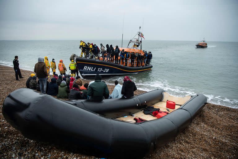 Migrantes son ayudados por el bote salvavidas RNLI (Royal National Lifeboat Institution) en la costa sureste de Inglaterra