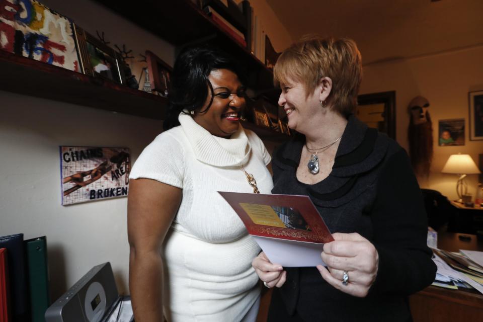 Lucy Neighbor laughs with Deborah Drennan, Freedom House's executive director, Friday, Feb. 10, 2017, in Detroit. With the help of several people, Neighbor escaped a jail where she was beaten and raped, secured a passport and U.S. tourist visa, and eventually found her way to Freedom House's front door in January 2008 from Cameroon. Neighbor, whose husband was fatally beaten during a government protest in their homeland, wasn't sure exactly what it was but felt at home the moment a worker from Africa opened the door.(AP Photo/Paul Sancya)