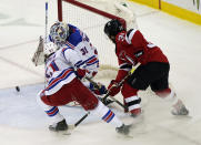 New York Rangers goaltender Igor Shesterkin (31) makes a save with Rangers center Brett Howden (21) helping on defense and New Jersey Devils Nicholas Merkley (39) threatening during the second period of an NHL hockey game, Tuesday, April 13, 2021, in Newark, N.J. (AP Photo/Kathy Willens)