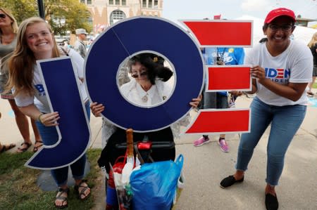 Bonnie Swalwell Eilert poses with a sign for Democratic 2020 U.S. presidential candidate Biden at the Iowa State Fair in Des Moines