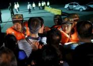 Family members of passengers of a sunken cruise ship push a cordon of paramilitary police as they march toward the site of the sunken ship in the Jianli section of Yangtze River, Hubei province, China, June 3, 2015. REUTERS/Kim Kyung-Hoon