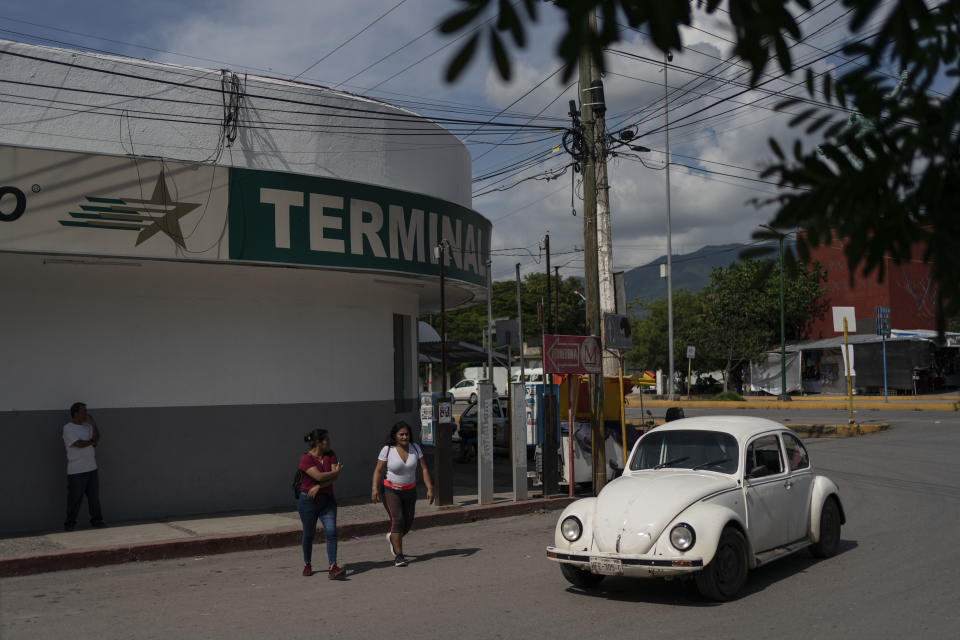 People walk outside the bus terminal in Iguala, Guerrero state, Mexico, Saturday, Sept. 7, 2024. Ten years ago, about 100 students from the Raúl Isidro Burgos Rural Normal School commandeered buses to drive themselves to a protest in the capital, but were attacked and 43 of them went missing. (AP Photo/Felix Marquez)