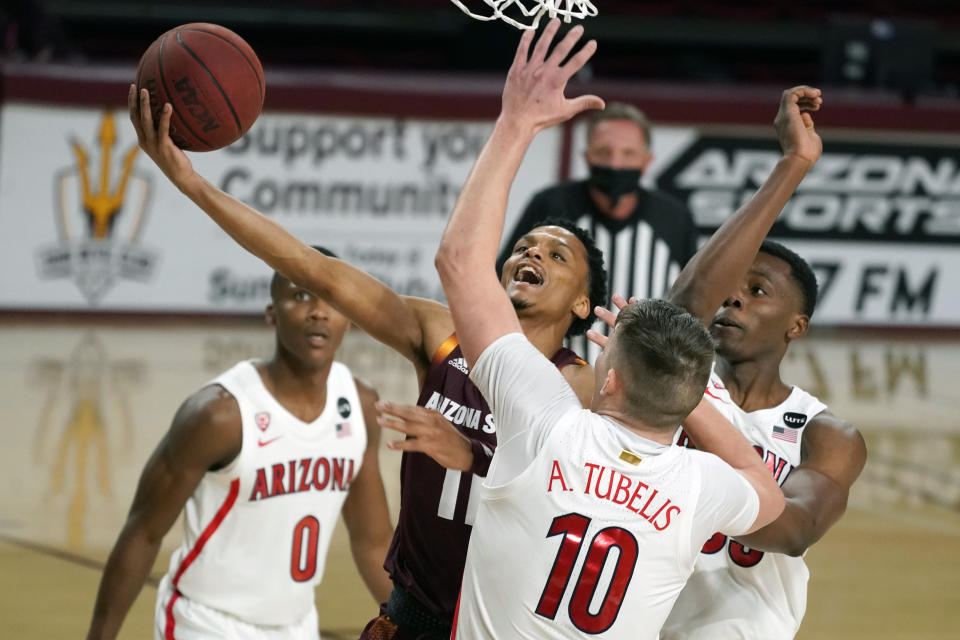 Arizona State guard Alonzo Verge Jr. drives between Arizona's Bennedict Mathurin (0), Azuolas Tubelis (10) and James Akinjo during the first half of an NCAA college basketball game Thursday, Jan. 21, 2021, in Tempe, Ariz. (AP Photo/Rick Scuteri)