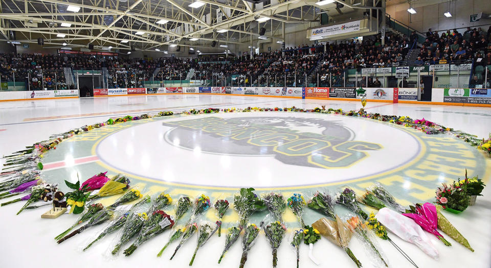 Flowers lie at centre ice as people gather for a vigil at the Elgar Petersen Arena. (Jonathan Hayward/CP)