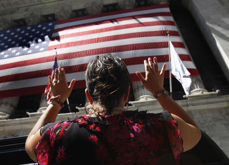 Una mujer haciendo yoga delante de la Bolsa de Nueva York, en Wall Street. REUTERS/Shannon Stapleton. 