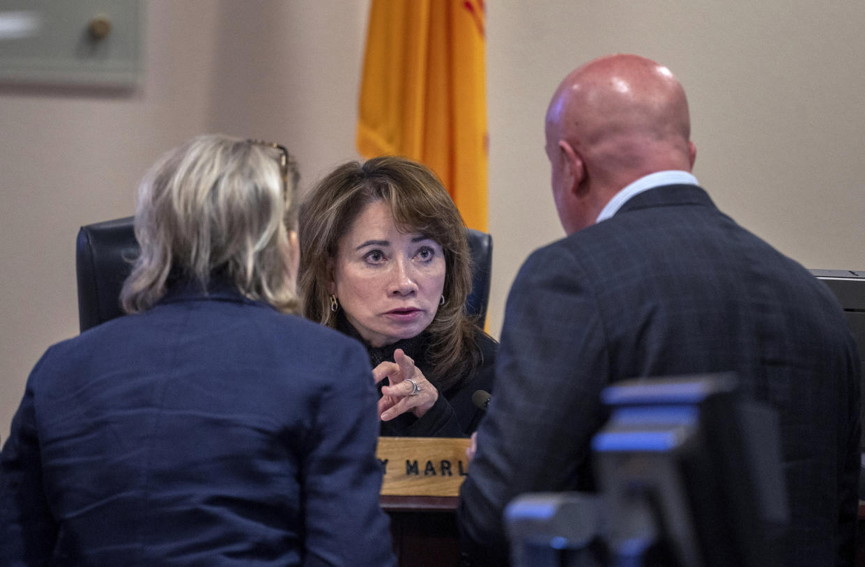 Prosecutor Kari Morrissey, left, and defense attorney Jason Bowles, right, confer with Judge Mary Marlowe Sommer