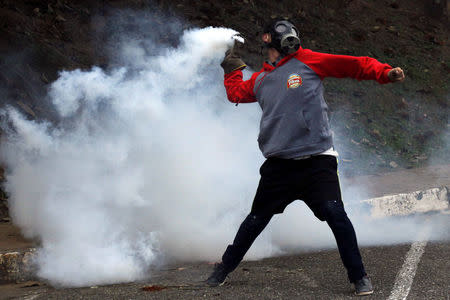 A demonstrator throws a tear gas canister back at the police during a protest against Venezuelan President Nicolas Maduro's government in San Cristobal, Venezuela April 5, 2017. REUTERS/Carlos Eduardo Ramirez