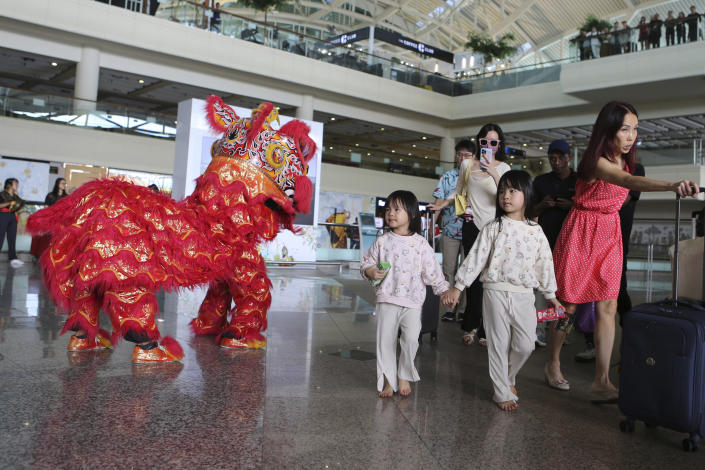 A lion dancer welcomes Chinese tourists on their arrival at Ngurah Rai international airport in Bali, Indonesia on Sunday, Jan. 22, 2023. A direct flight from China landed in Indonesia's resort island of Bali for the first time on Sunday in nearly three years after the route was cancelled due to the pandemic. (AP Photo/Firdia Lisnawati)