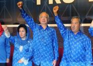 Malaysian Prime Minister Najib Razak (centre), his wife Rosmah Mansor (left) and Deputy Prime Minister Muhyiddin Yassin celebrate the Barisan Nasional coalition's election victory on May 6, 2013 in Kuala Lumpur. Razak was sworn in for a second term by Malaysia's king on Monday, after his 56-year-old ruling coalition retained power in elections branded as fraudulent by the opposition