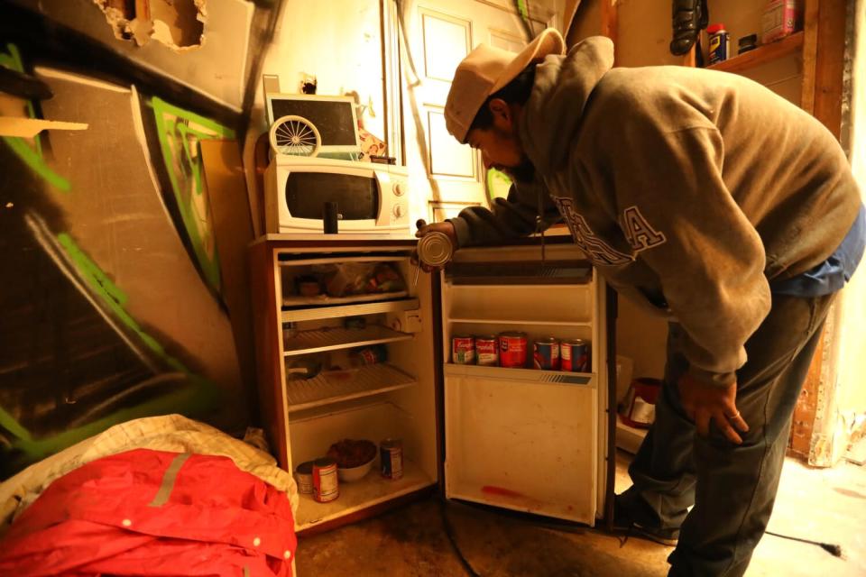 A man looks inside a mini-fridge