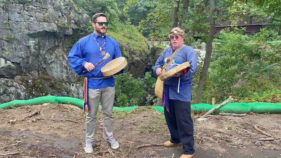 Mohegan Tribe Outreach Specialist Dave Eichelberg and Mohegan Tribal Council of Elders Secretary Chris Harris performing a Mohegan song during the Uncas Leap Heritage Park groundbreaking on Thursday