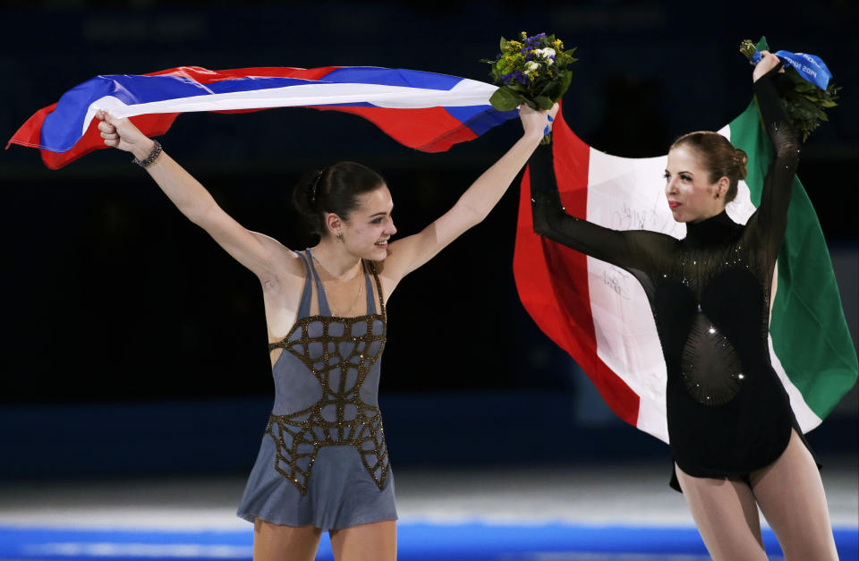 Adelina Sotnikova of Russia, left, and Carolina Kostner of Italy celebrate following the flower ceremony for the women's free skate figure skating finals at the Iceberg Skating Palace during the 2014 Winter Olympics, Thursday, Feb. 20, 2014, in Sochi, Russia. Sotnikova placed first, followed by Kim and Kostner. (AP Photo/Bernat Armangue)