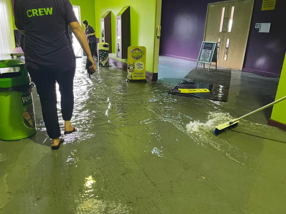 Members of staff at The Milky Way in Devon, clearing out floodwater inside the premises (Steff Gaulter/PA Wire)