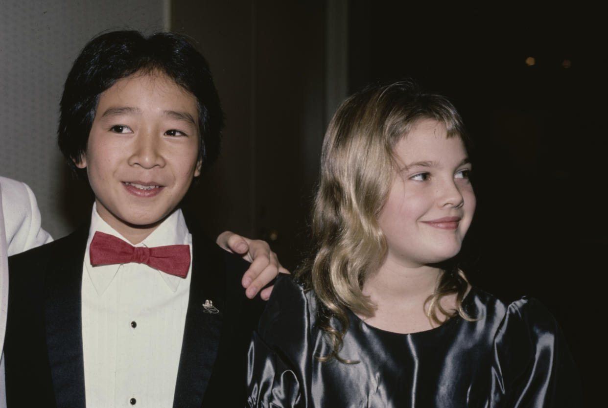 American actor Ke Huy Quan, wearing a tuxedo with a red bow tie, and American actress Drew Barrymore, wearing a grey silk outfit with a round neckline, attend the 6th Youth in Film Awards, in Los Angeles, California, 2nd December 1984. Barrymore is nominated for the Best Young Actress in a Motion Picture (Musical, Comedy, Adventure or Drama) award for her performance in 'Irreconcilable Differences', and Quan is nominated for the Best Young Supporting Actor in a Motion Picture (Musical, Comedy, Adventure or Drama) award for his performance in 'Indiana Jones and the Temple of Doom'. (Photo by Vinnie Zuffante/Michael Ochs Archives/Getty Images)