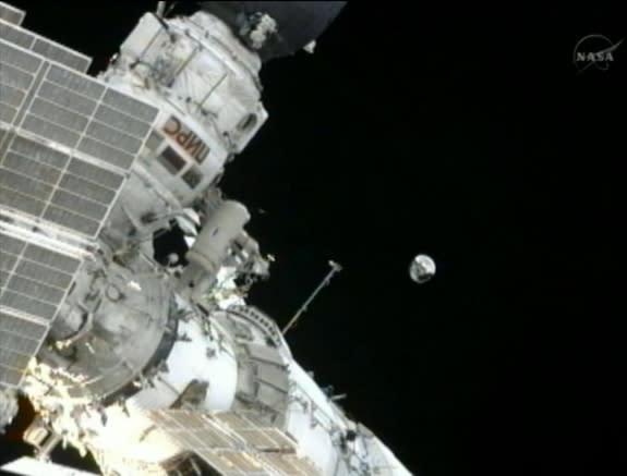 Expedition 32 commander Gennady Padalka, a Russian cosmonaut, throws the small Spherical Satellite into orbit during an Aug. 20, 2012, spacewalk outside the International Space Station. The small satellite will spend three months in orbit and b