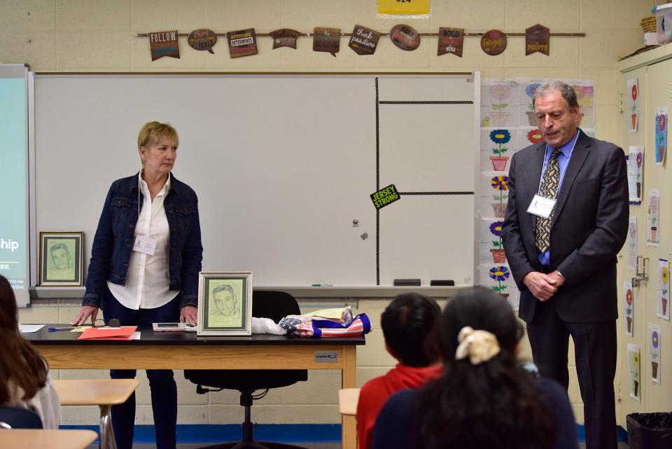 Debra Doppelt, Author of A Mother's Journey, which is about her son Joshua's struggles with medications and overdose of Oxycodone in 2008, looks at her husband Gerald speaking to seventh graders during the Living Lessons: Voices, Visions and Values at Robert Lazar Middle School, Thursday on 05/19/22.