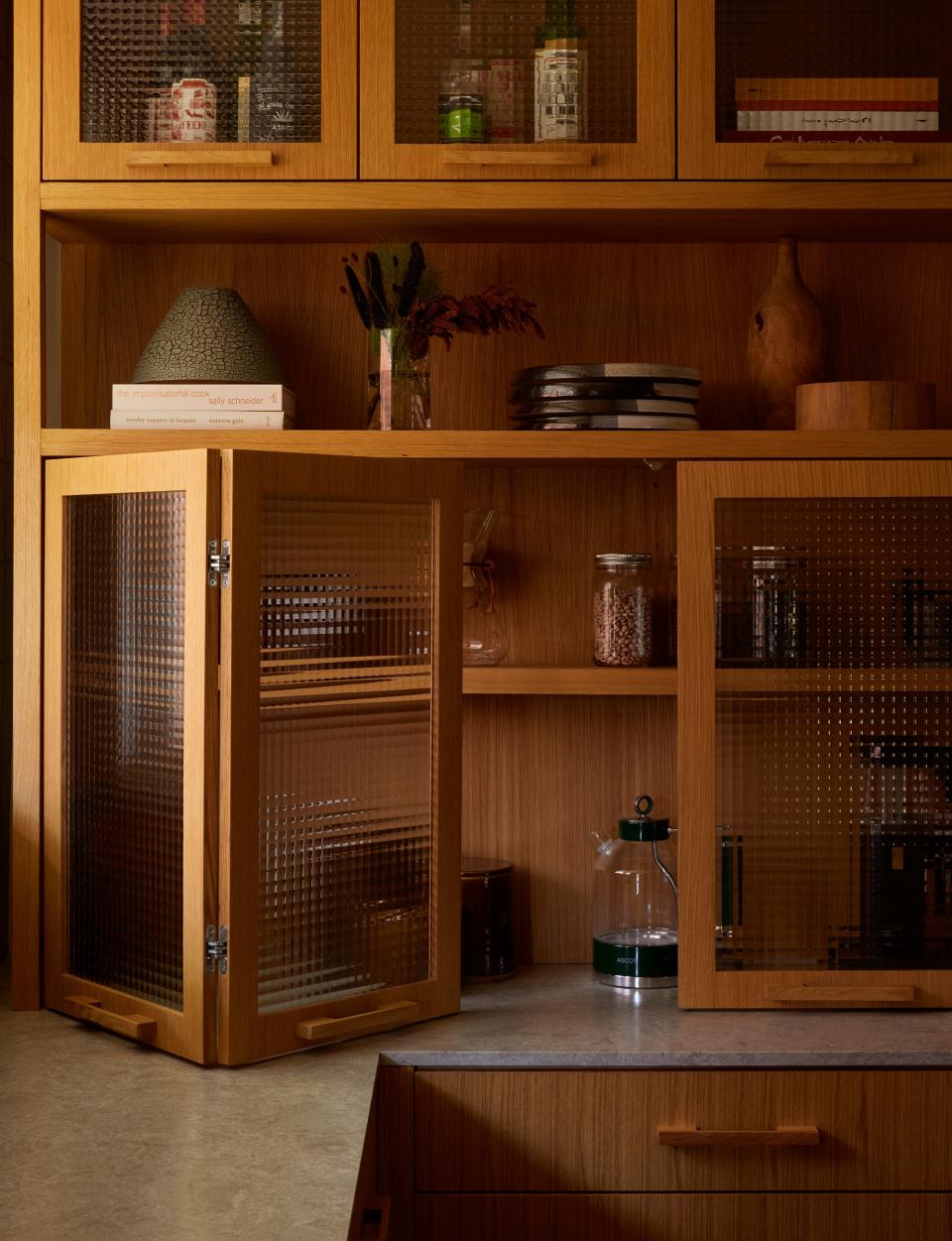 AFTER: “The wood-and-glass cabinet was designed in an effort to further break up the wood cabinetry, but to also add a reflective detail,” Patrick says. Yeehaw Woodworks oversaw all of the millwork.