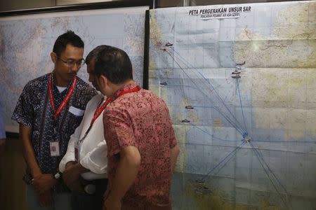 Indonesia Air Asia CEO Sunu Widyatmoko (L) talks with Air Asia CEO Tony Fernandes (C) in front of map for the joint Search and Rescue team for AirAsia flight QZ8501, at Surabaya's Juanda International Airport December 29, 2014. REUTERS/Beawiharta