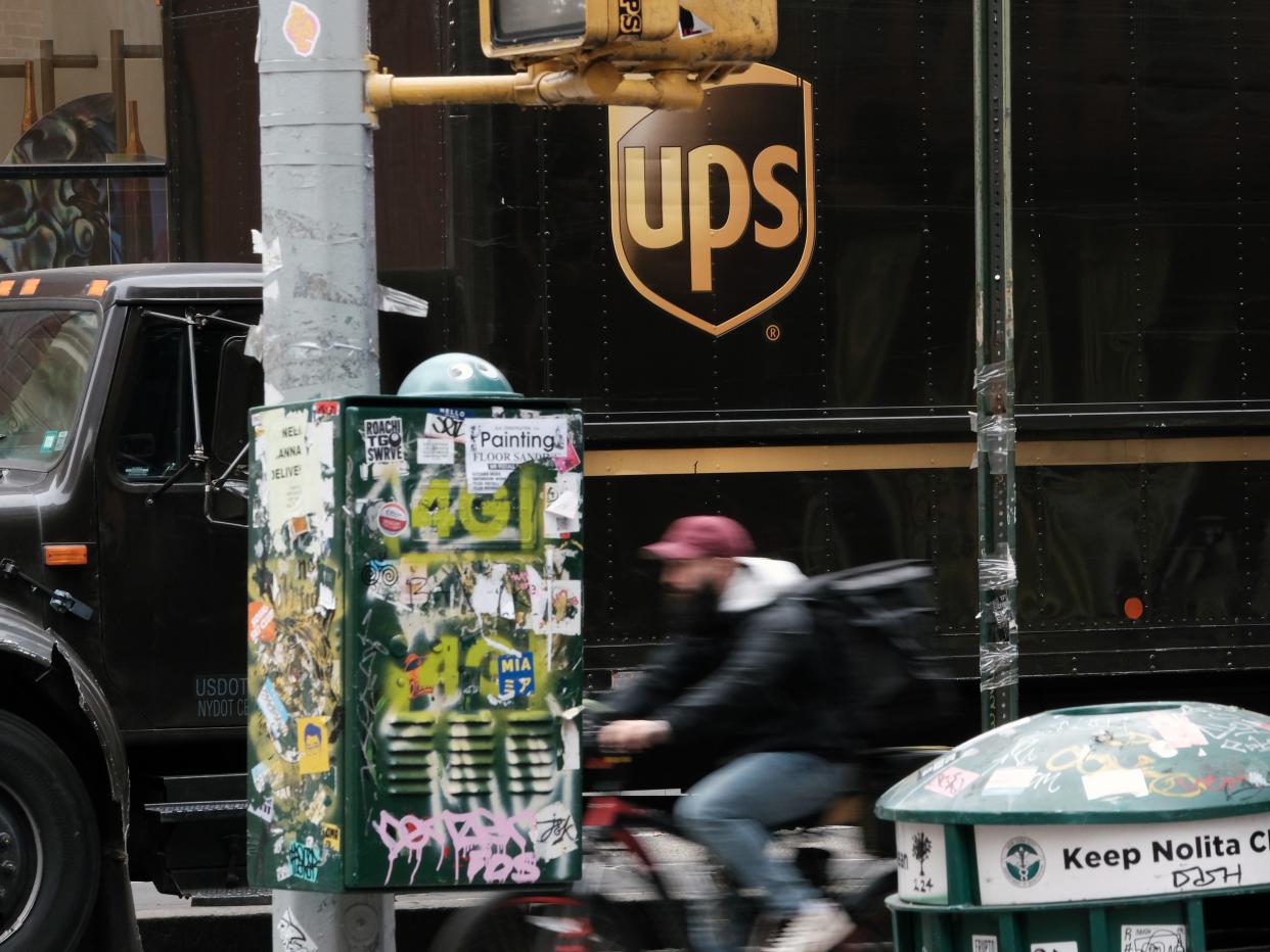 A bike rides in front of a brown UPS truck in Manhattan.