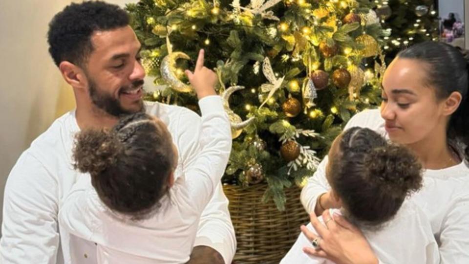 Leigh-Anne Pinnock and Andre Gray holding their children in front of a Christmas tree