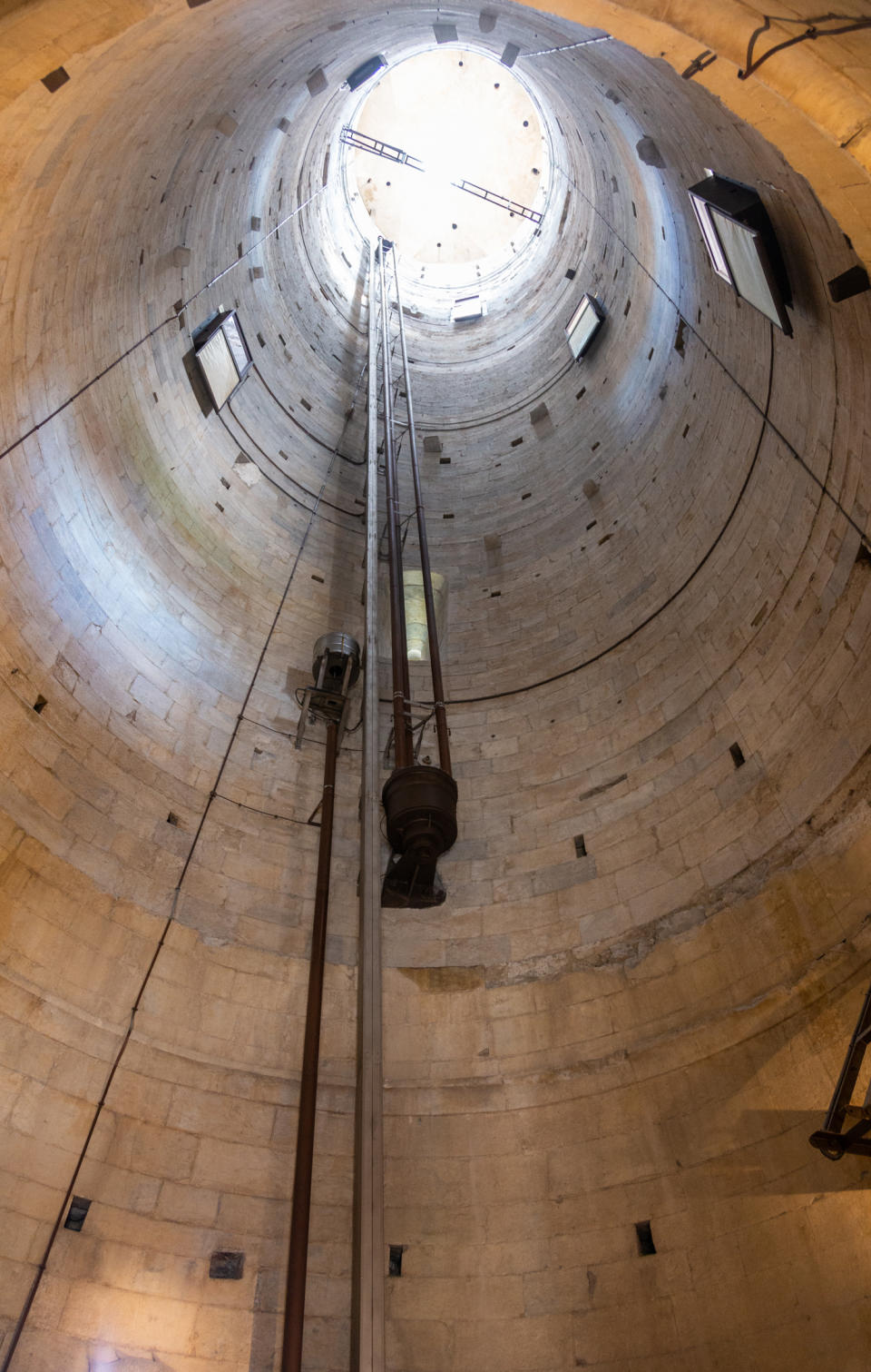 The interior of a hollow tower with light coming in at the top