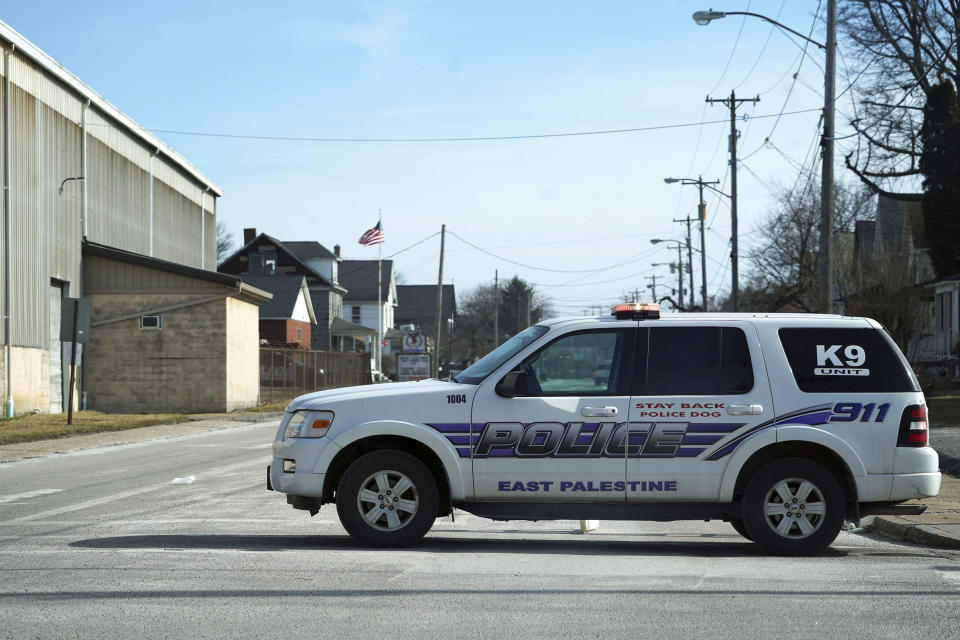 East Palestine police block roads in downtown East Palestine, Ohio, on Sunday, Feb. 5, 2023. A smoldering tangle of dozens of derailed freight cars, some carrying hazardous materials, has kept an evacuation order in effect in Ohio near the Pennsylvania state line as environmental authorities warily watch air quality monitors. (Lucy Schaly/Pittsburgh Post-Gazette via AP)