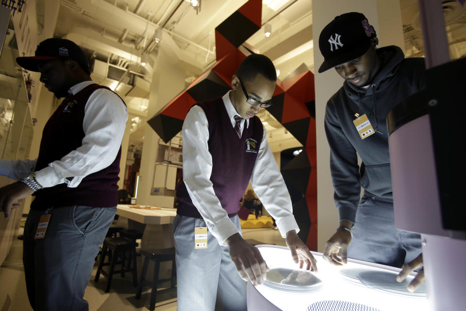 Bronx Preparatory Charter School students Shakeel Hawker, right, Pablo Guante, center, and Shaquille Beeston look at some of the interactive displays at the new National Museum of Mathematics in New York, Monday, Dec. 17, 2012. The museum is aimed at kids aged 8 to 13, and curators have given the place a playground feel. The 40 exhibits include a "wall of fire" made up of laser lights that teaches kids about geometry and a square-wheeled tricycle that still manages to produce a smooth ride thanks to a wavy track. (AP Photo/Seth Wenig)