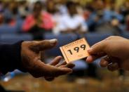 A tax officer (R) gives a number to a man queueing for tax amnesty at the country's tax headquarters in Jakarta, Indonesia September 30, 2016. REUTERS/Beawiharta