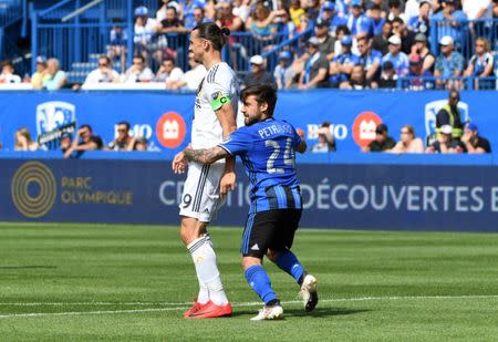 May 21, 2018; Montreal, Quebec, CAN; Montreal Impact defender Michael Petrasso (24) and Los Angeles Galaxy forward Zlatan Ibrahimovic (9) during the first half at Stade Saputo. Mandatory Credit: Eric Bolte-USA TODAY Sports