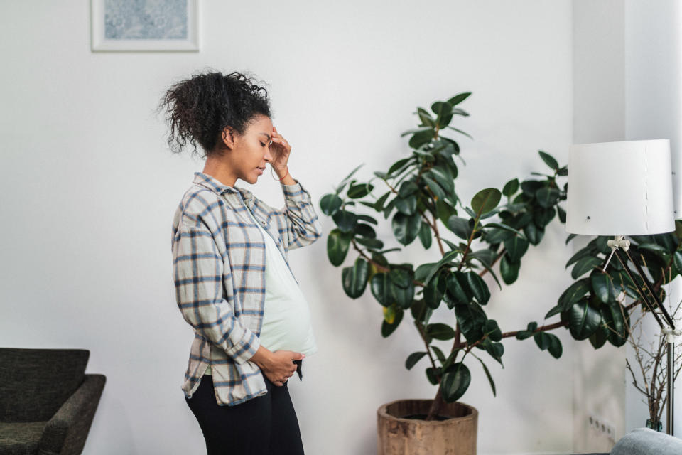 Pregnancy headache. Black pregnant woman feeling tired and exhausted