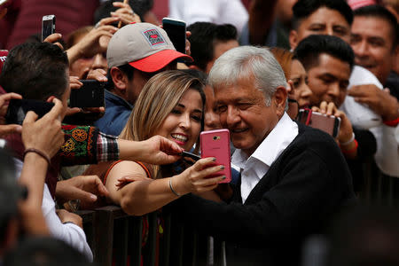 Andres Manuel Lopez Obrador, leader of the National Regeneration Movement (MORENA), takes a selfie with supporters as he arrives to his rally at Mexican revolution monument in Mexico City, Mexico September 3, 2017. REUTERS/Carlos Jasso