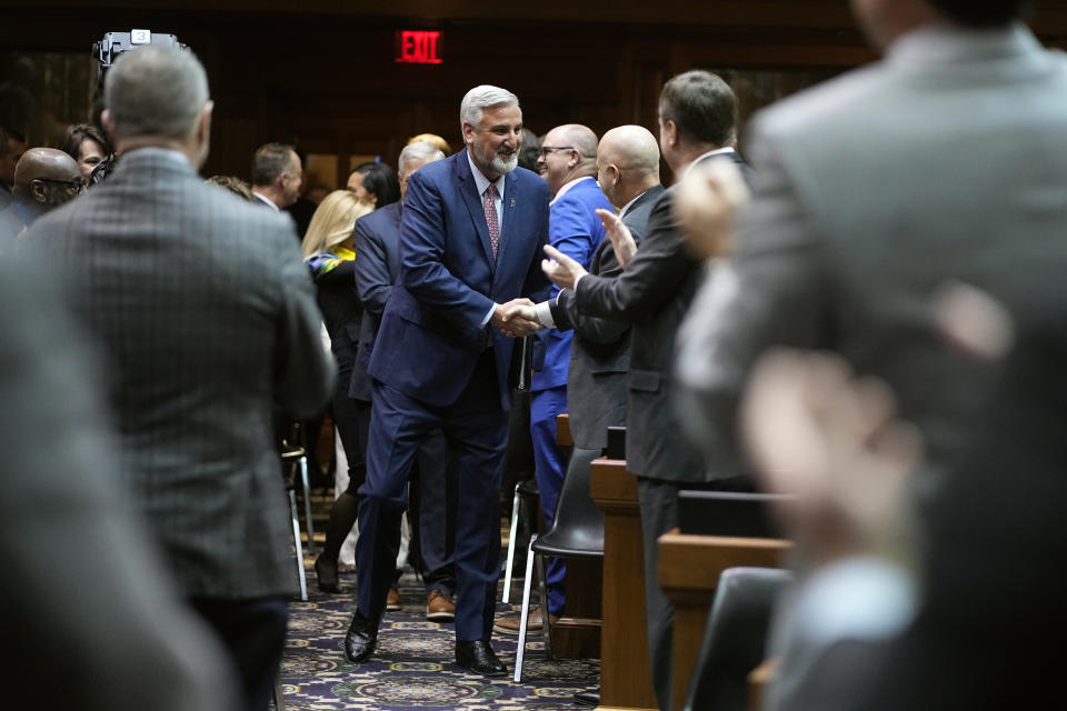 Indiana Gov. Eric Holcomb greets legislators before delivering his State of the State address to a joint session of the legislature at the Statehouse, Tuesday, Jan. 10, 2023, in Indianapolis. (AP Photo/Darron Cummings)