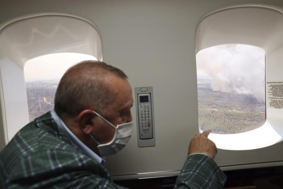 Turkey's President Recep Tayyip Erdogan watches from his plane the wildfires in Manavgat, Antalya, Turkey, Saturday, July 31, 2021. The death toll from wildfires raging in Turkey's Mediterranean towns rose to six Saturday after two forest workers were killed, the country's health minister said. Fires across Turkey since Wednesday burned down forests, encroaching on villages and tourist destinations and forcing people to evacuate.(Turkish Presidency via AP, Pool)