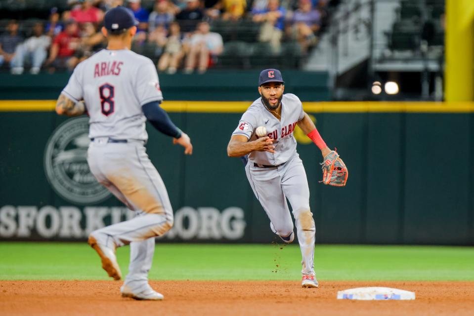 Cleveland Guardians shortstop Amed Rosario, right, tosses the ball to third baseman Gabriel Arias for an out during the fourth inning of a baseball game against the Texas Rangers in Arlington, Texas on Sunday, Sept. 25, 2022. (AP Photo/Gareth Patterson)