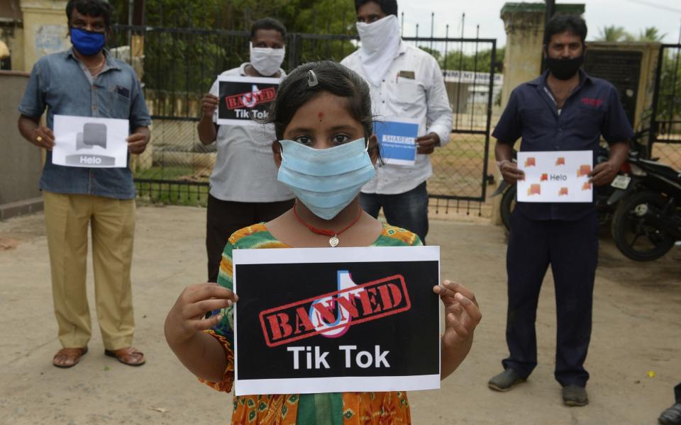 Members of the City Youth Organisation hold posters with the logos of Chinese apps in support of the Indian government for banning the wildly popular video-sharing 'Tik Tok' app, in Hyderabad on June 30, 2020 - Noah Seelam/AFP