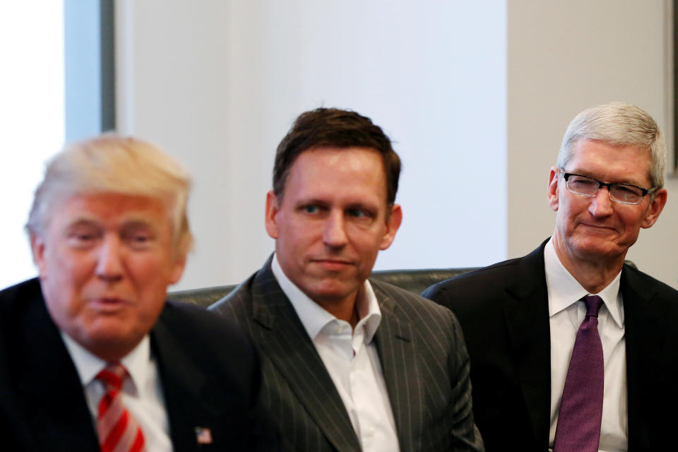 Then U.S. President-elect Donald Trump speaks as PayPal co-founder and Facebook board member Peter Thiel and Apple Inc CEO Tim Cook look on during a meeting with technology leaders at Trump Tower in New York U.S. on December 14, 2016. REUTERS/Shannon Stapleton/File Photo