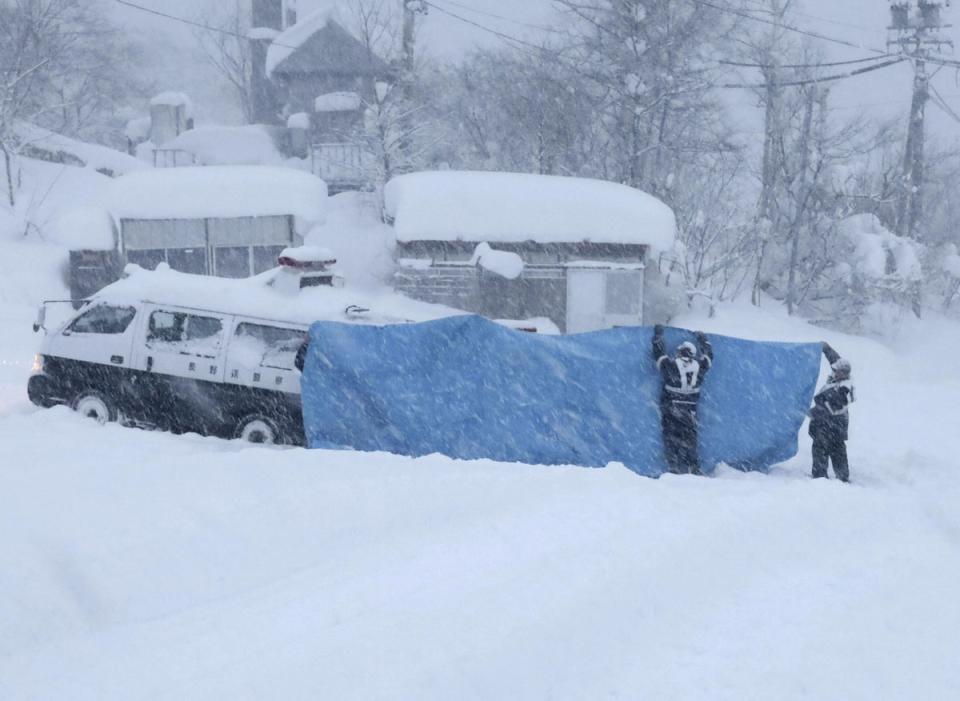 Police officers try to transport victims found at an accident site following an avalanche the previous day, in the village of Otari in Nagano Prefecture, central Japan, January 30, 2023 (via REUTERS)