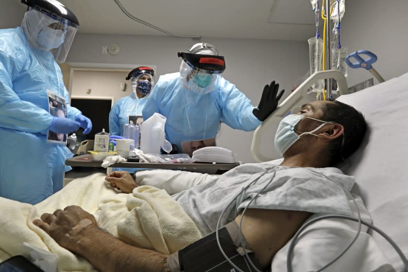 HOUSTON, TEXAS-MAY 6, 2020-Dr. Joseph Varon, the doctor in charge of the COVID-19 unit at United Memorial Medical Center in north Houston, checks on COVID patient Melquiades Cervantes, 43, who was hoping to be released this week. (Carolyn Cole/Los Angeles Times)