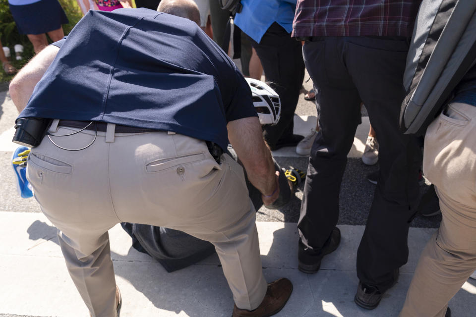 President Joe Biden is helped by U.S. Secret Service Agents after falling from his bike as he tried to get off his bike to greet a crowd on a trail at Gordons Pond in Rehoboth Beach, Del., Saturday, June 18, 2022. (AP Photo/Manuel Balce Ceneta)