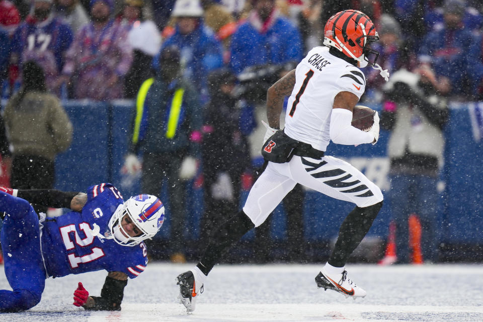 Cincinnati Bengals wide receiver Ja'Marr Chase (1) runs in a touchdown after catching a pass against Buffalo Bills safety Jordan Poyer (21) during the first quarter of an NFL division round football game, Sunday, Jan. 22, 2023, in Orchard Park, N.Y. (AP Photo/Seth Wenig)