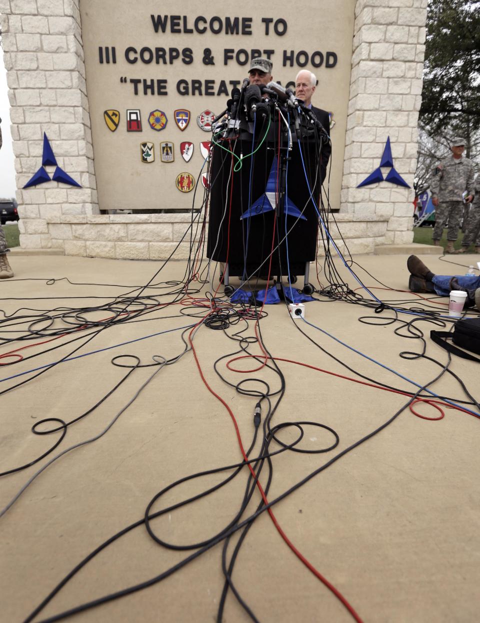 Lt. Gen. Mark Milley, left,and U.S. Sen. John Cornyn, right, talk to the media near Fort Hood's main gate, Thursday, April 3, 2014, in Fort Hood, Texas. A soldier opened fire Wednesday on fellow service members at the Fort Hood military base, killing three people and wounding 16 before committing suicide. (AP Photo/Eric Gay)