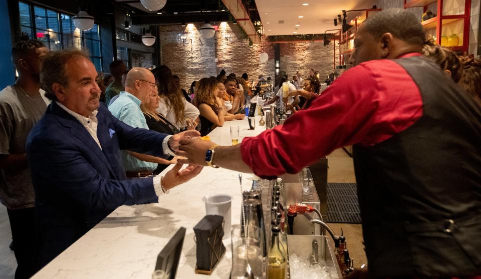 People enjoy food and drink during the Hyatt Caption grand opening ceremony Thursday, July 14, 2022, in Memphis.